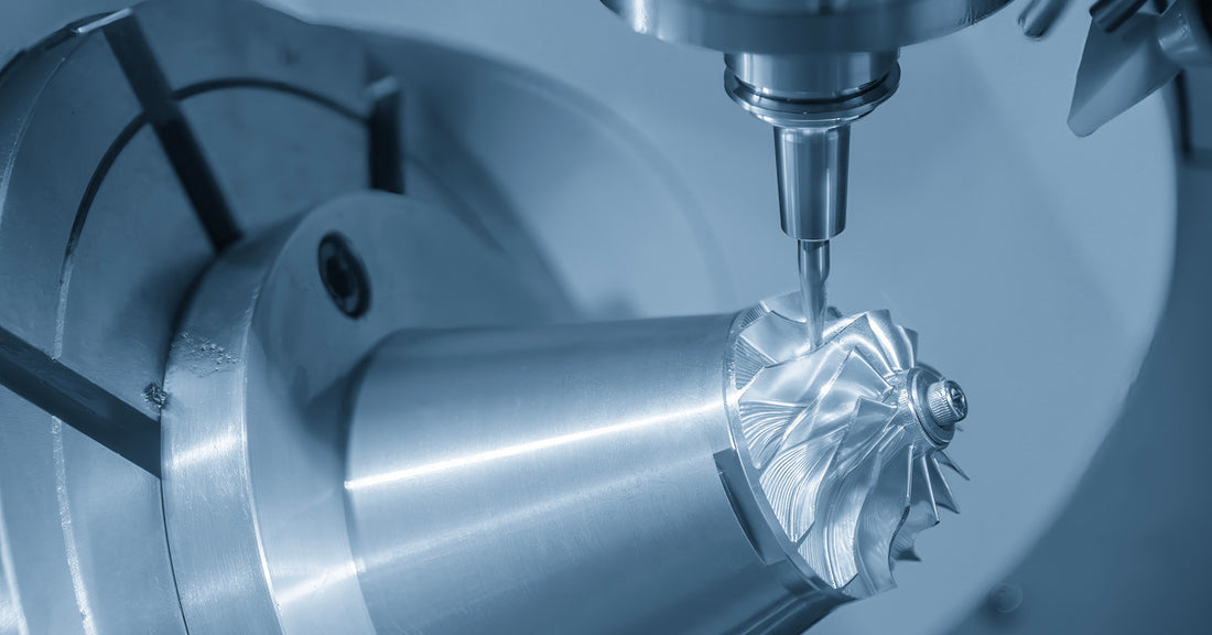 Close-up view of a CNC machine milling a metallic turbocharger impeller with visible precision and fine cutting details.