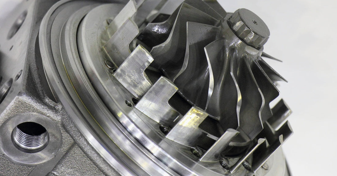 A close-up view of a sleek, silver turbocharger showcasing its propeller and motor, ready for mechanical tuning.