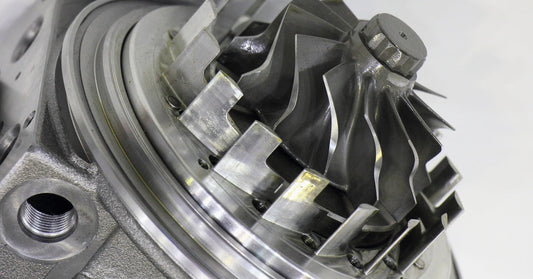 A close-up view of a sleek, silver turbocharger showcasing its propeller and motor, ready for mechanical tuning.