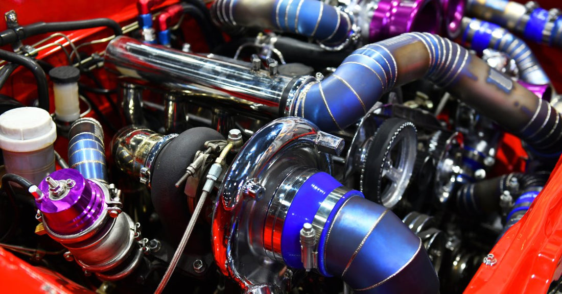 A vibrant aftermarket performance turbo setup in a custom engine, featuring colorful pipes and polished components.